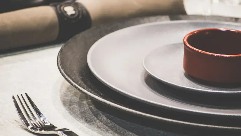 Schoon servies met borden en bestek klaar op tafel