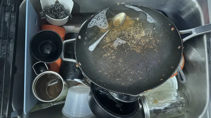 Spoelbak met vuile borden en pannen die op de afwas wachten