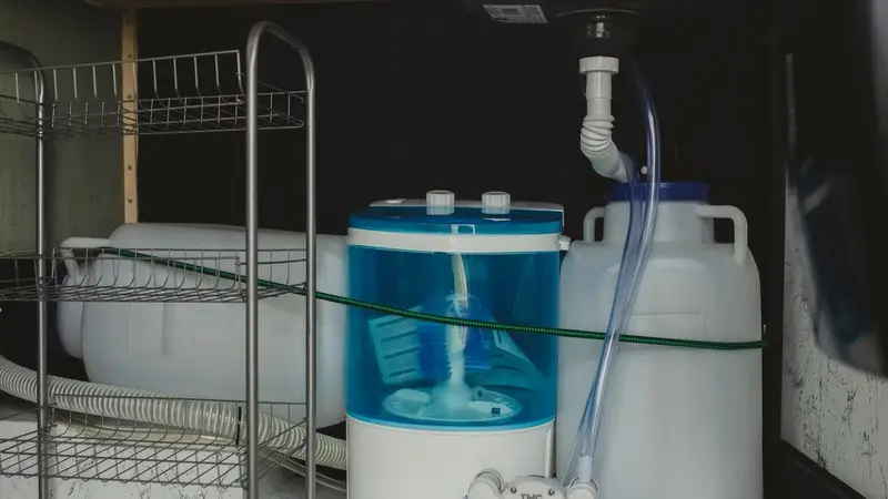 Waterleidingen en aansluitingen onder de spoelbak in een keuken