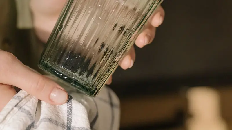 Glas dat na het vaatwasprogramma met een doek wordt nagedroogd